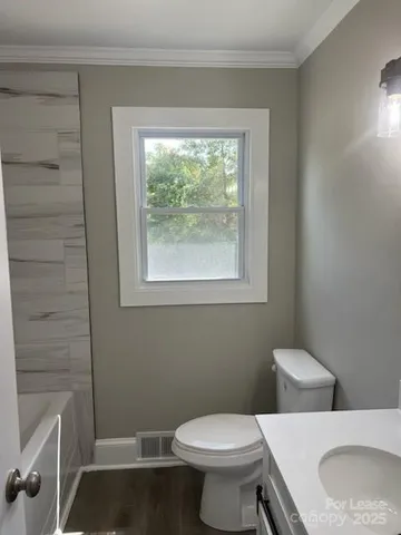 a white toilet sitting next to a bathroom sink