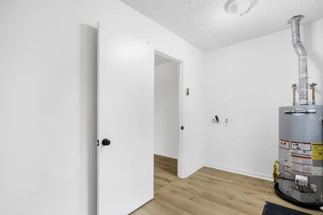 a view of an empty room with wooden floor and closet