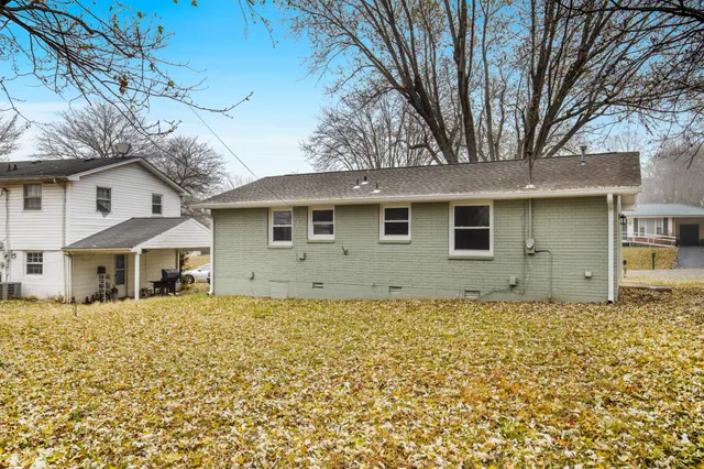 a view of a white house with a large tree