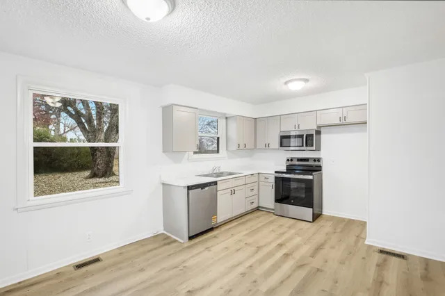 a kitchen with stainless steel appliances granite countertop a stove and a refrigerator