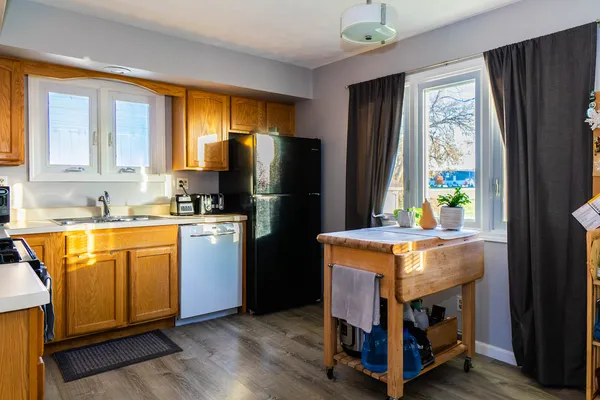 a kitchen with refrigerator a stove a sink and a window
