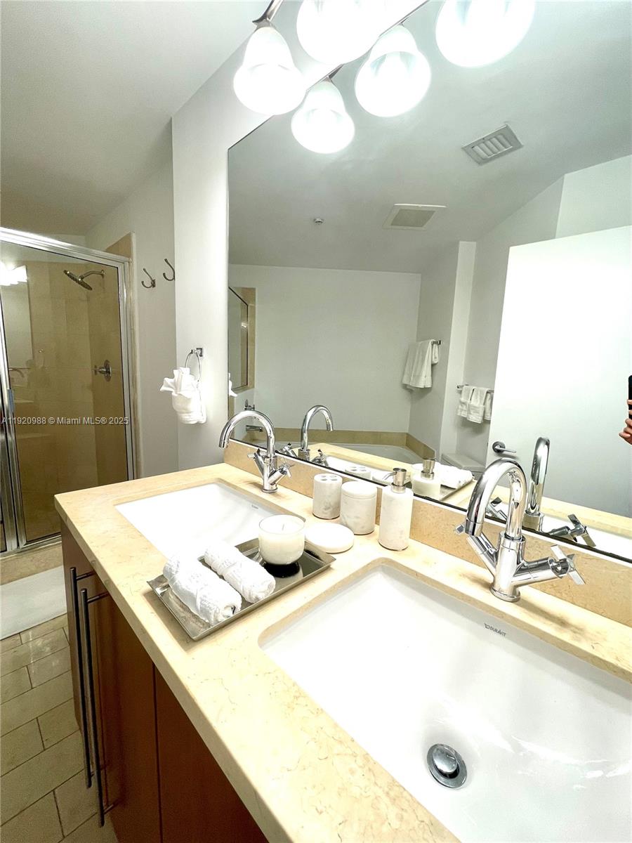 79 Southwest 12th Street, Unit 2407S Miami, FL 33130 - Photo 11 of 35 a bathroom with a sink double vanity and a mirror