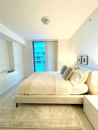 a bedroom with a bed and a night stand