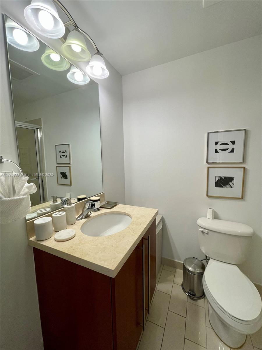 79 Southwest 12th Street, Unit 2407S Miami, FL 33130 - Photo 18 of 35 a bathroom with a toilet sink and mirror