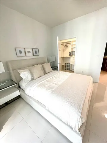 a large bed sitting in a bedroom next to a window