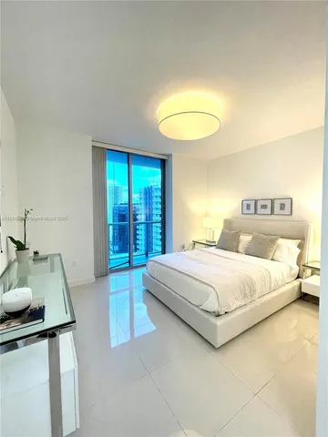 a spacious bedroom with a bed and a dresser