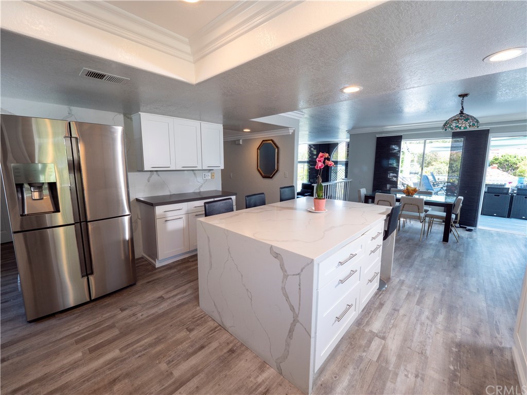 33881 Orilla Road Dana Point, CA 92629 - Photo 23 of 37 a large kitchen with stainless steel appliances a stove a refrigerator a sink dishwasher and a dining table with wooden floor