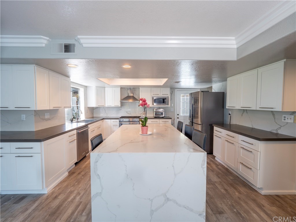 33881 Orilla Road Dana Point, CA 92629 - Photo 24 of 37 a kitchen with stainless steel appliances kitchen island granite countertop a refrigerator a sink dishwasher and a stove with wooden floor