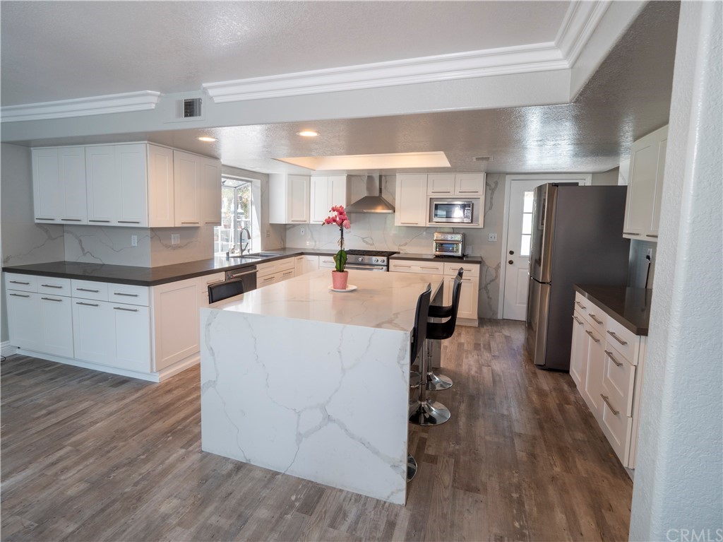 33881 Orilla Road Dana Point, CA 92629 - Photo 25 of 37 a dining hall with stainless steel appliances granite countertop a refrigerator a sink dishwasher a dining table and chairs with wooden floor