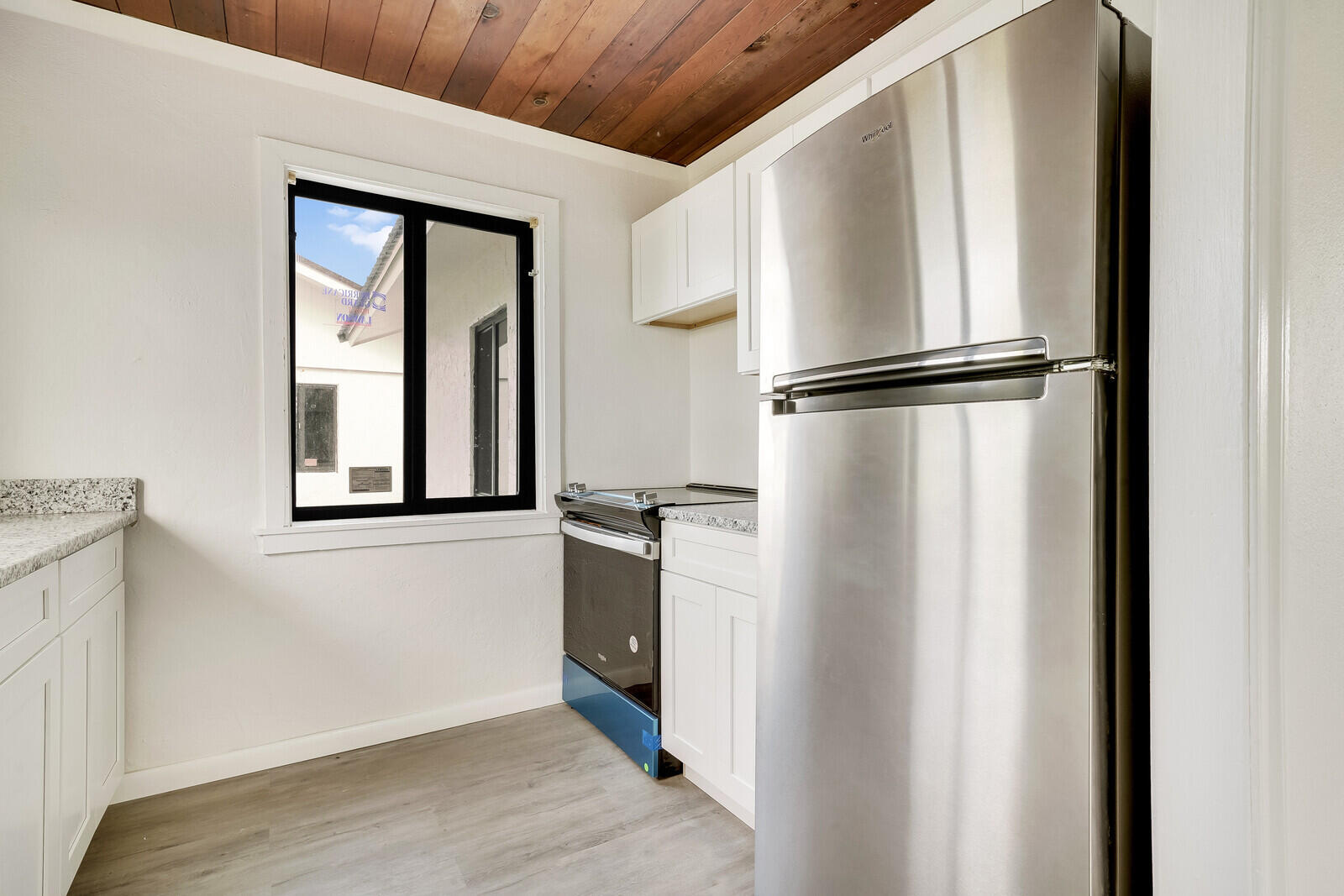 652 Hernando Street, Unit E Fort Pierce, FL 34949 - Photo 14 of 21 a view of a refrigerator in kitchen and wooden floor