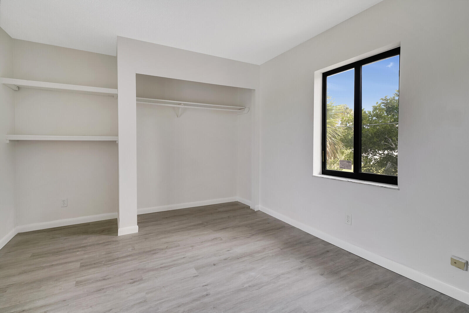 652 Hernando Street, Unit E Fort Pierce, FL 34949 - Photo 20 of 21 an empty room with wooden floor and windows