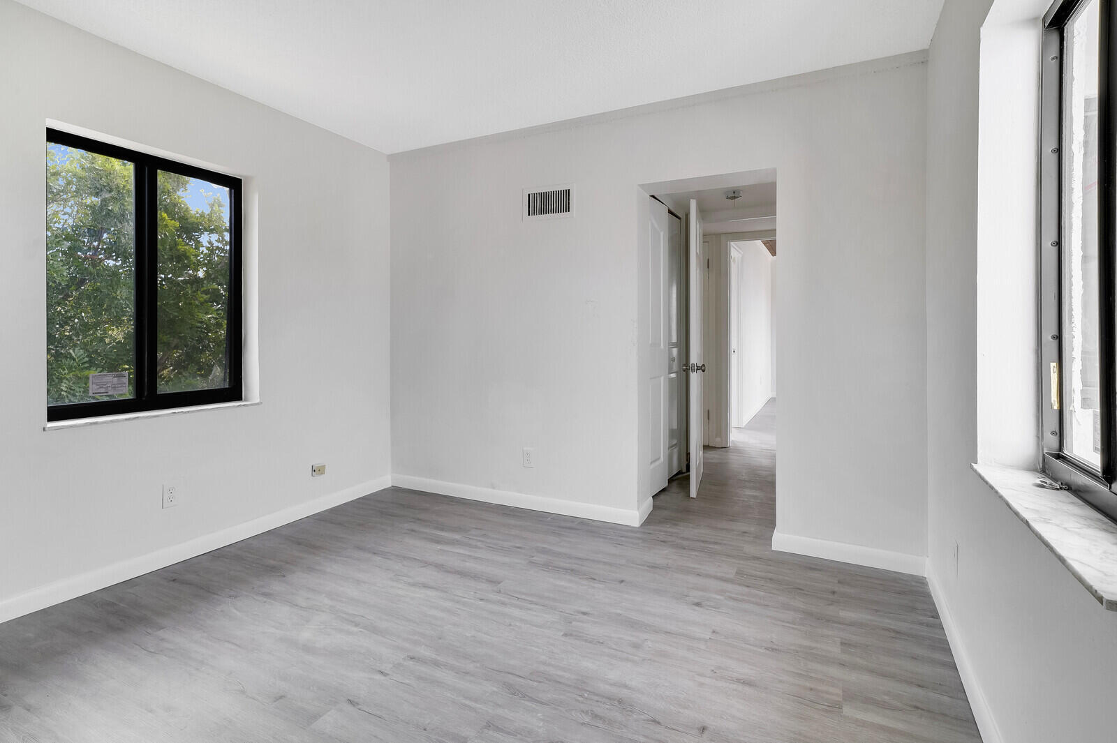 652 Hernando Street, Unit E Fort Pierce, FL 34949 - Photo 21 of 21 a view of an empty room with wooden floor and a window