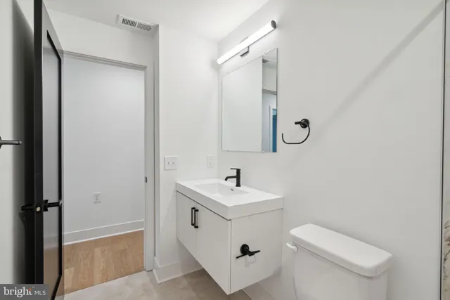 a bathroom with a sink toilet and mirror