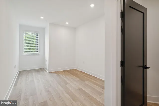 an empty room with wooden floor and a window
