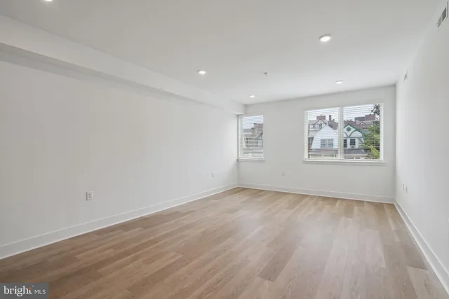 an empty room with wooden floor and window