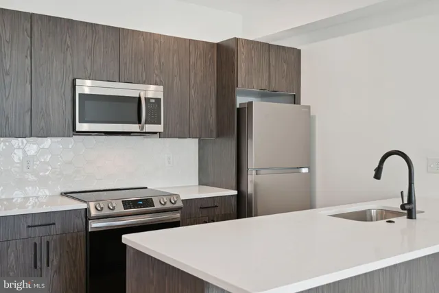 a kitchen with a stove a refrigerator and a microwave