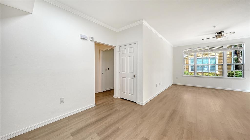 5561 Rosehill Road, Unit 104 Sarasota, FL 34233 - Photo 11 of 53 an empty room with wooden floor and windows