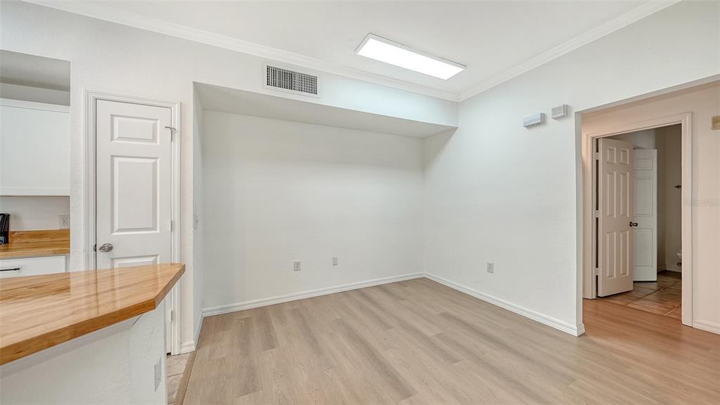 5561 Rosehill Road, Unit 104 Sarasota, FL 34233 - Photo 12 of 53 an empty room with wooden floor and a sink