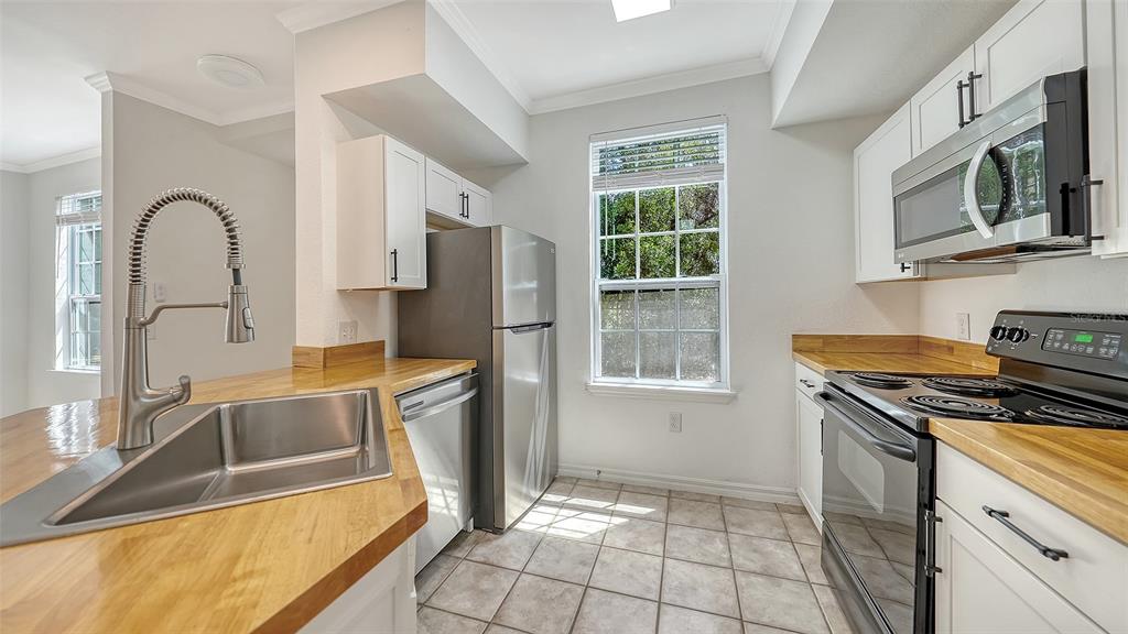 5561 Rosehill Road, Unit 104 Sarasota, FL 34233 - Photo 15 of 53 a kitchen with stainless steel appliances granite countertop a sink stove and refrigerator