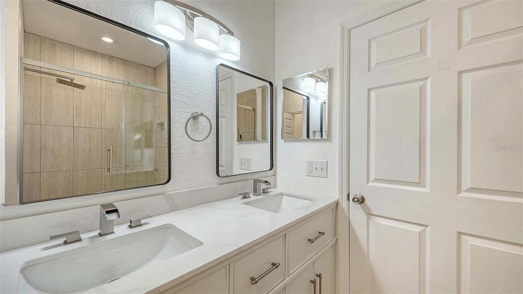 5561 Rosehill Road, Unit 104 Sarasota, FL 34233 - Photo 26 of 53 a bathroom with a double vanity sink and a mirror