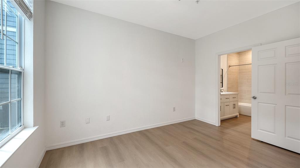 5561 Rosehill Road, Unit 104 Sarasota, FL 34233 - Photo 31 of 53 an empty room with wooden floor and windows