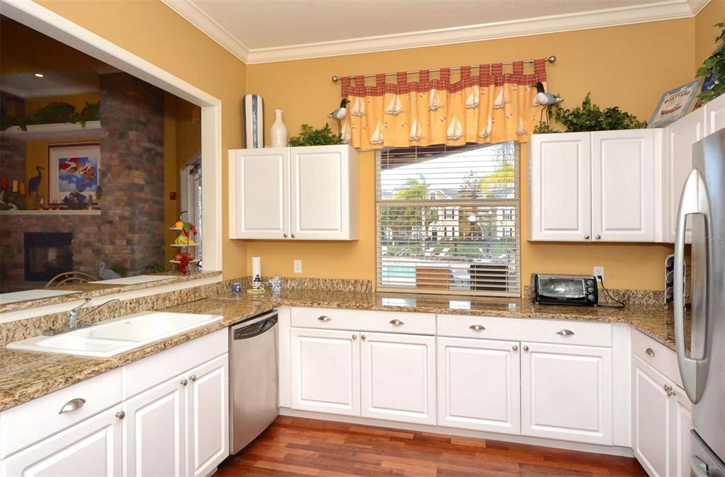 5561 Rosehill Road, Unit 104 Sarasota, FL 34233 - Photo 48 of 53 a kitchen with granite countertop white cabinets and white appliances