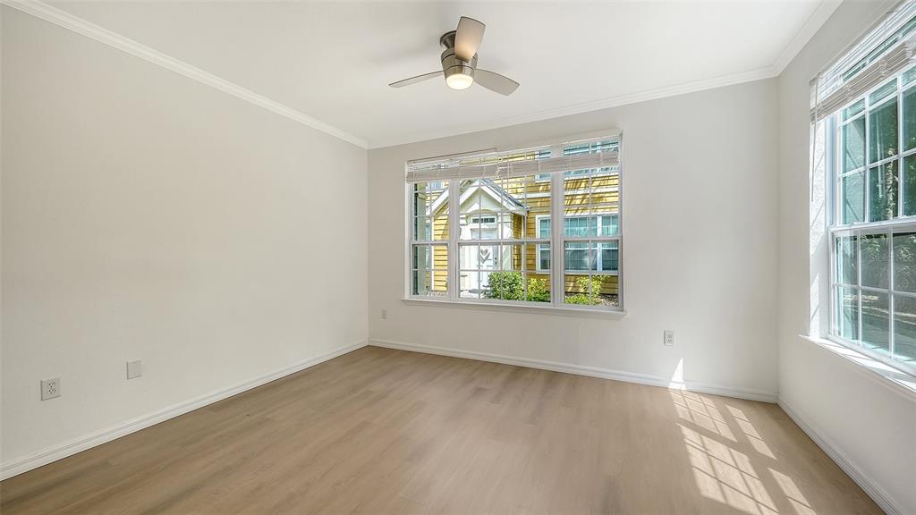 5561 Rosehill Road, Unit 104 Sarasota, FL 34233 - Photo 7 of 53 an empty room with wooden floor chandelier fan and windows