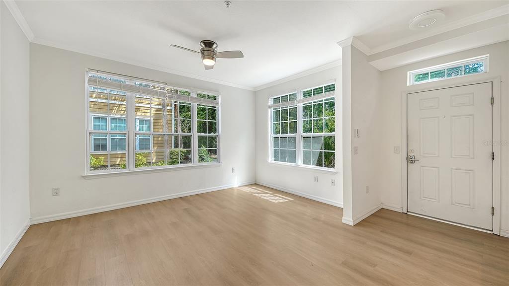 5561 Rosehill Road, Unit 104 Sarasota, FL 34233 - Photo 8 of 53 a view of an empty room with a window and wooden floor