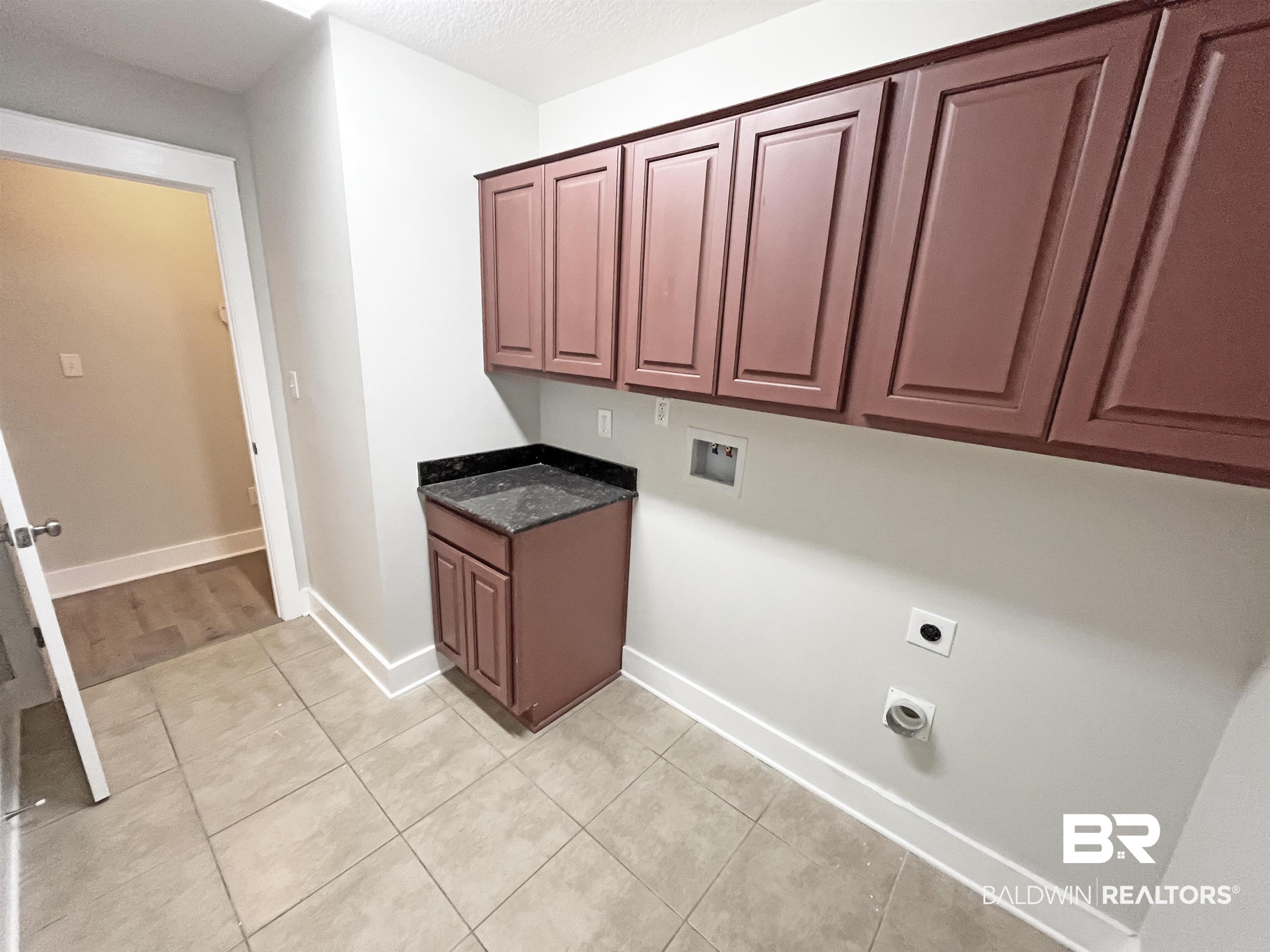 22023 Garland Loop Silverhill, AL 36576 - Photo 27 of 33 Washroom featuring cabinet space, hookup for an electric dryer, light tile patterned flooring, and hookup for a washing machine