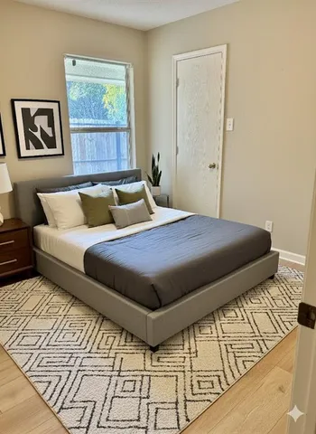 a bedroom with a bed and painting on the wall