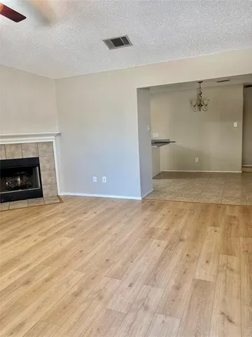 a view of empty room with a fireplace and wooden floor