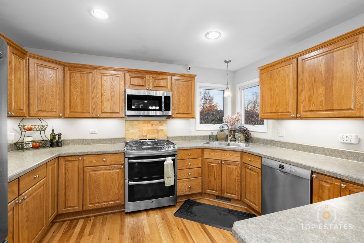 2303 Fox Bluff Lane Spring Grove, IL 60081 - Photo 14 of 39 a kitchen with stainless steel appliances granite countertop a stove a sink dishwasher and a microwave oven with cabinets