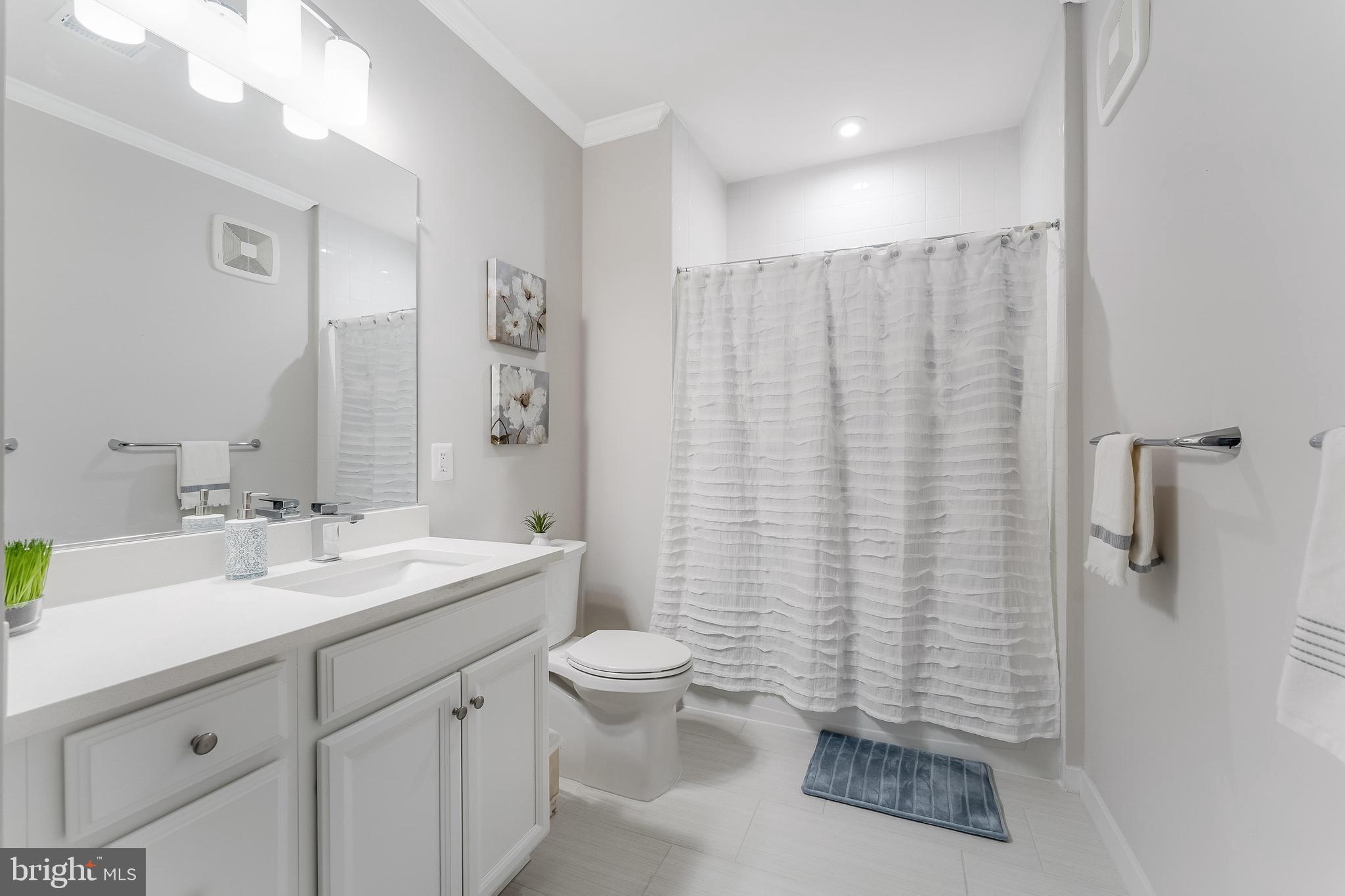 1675 Bandit Loop, Unit 105B Reston, VA 20190 - Photo 22 of 27 a bathroom with a double vanity sink toilet and a mirror