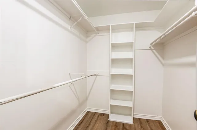 a view of walk in closet with empty racks