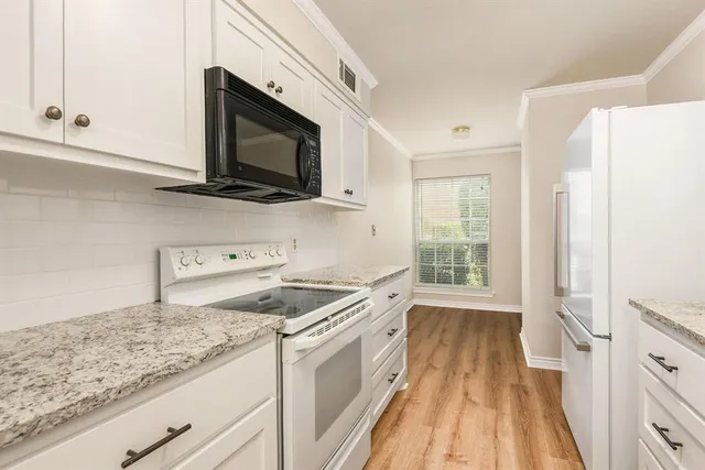 a kitchen with granite countertop a sink and a stove top oven
