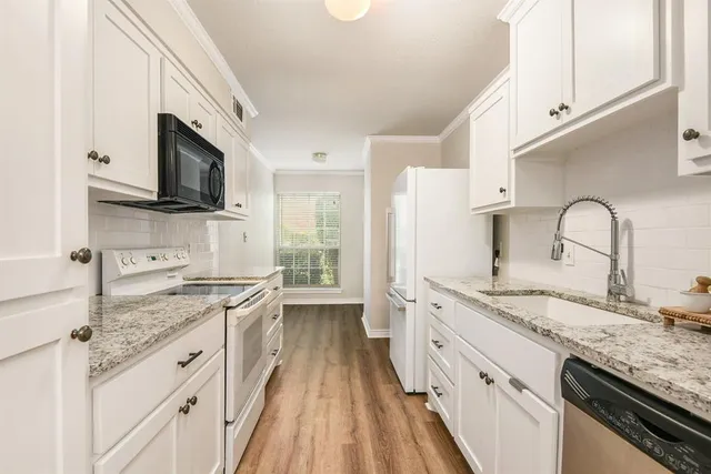 a kitchen with granite countertop a sink stove and refrigerator