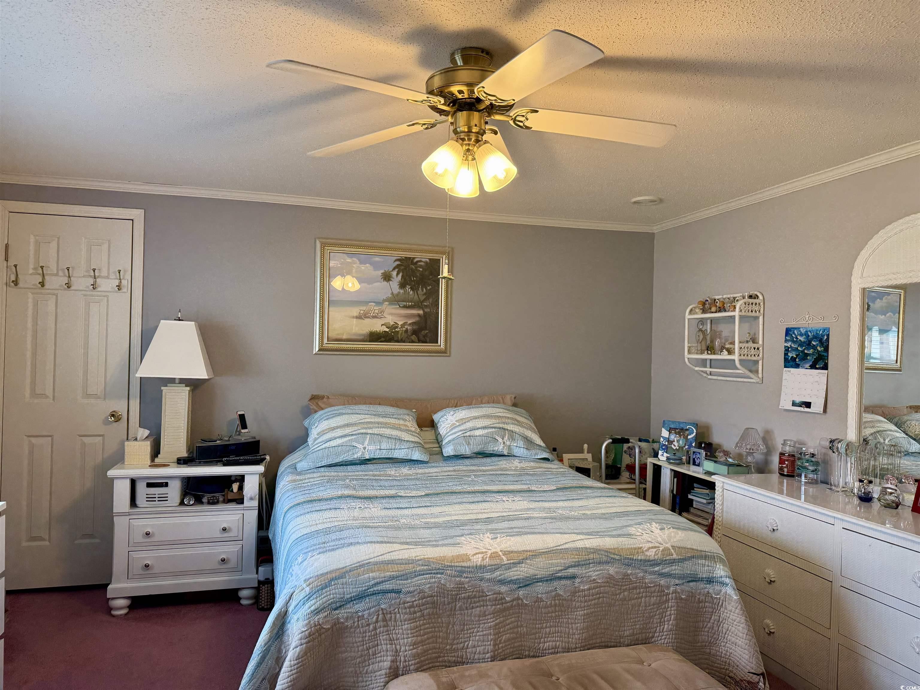 1506 Mason Circle Surfside Beach, SC 29575 - Photo 11 of 33 Bedroom with crown molding, dark colored carpet, a textured ceiling, and ceiling fan