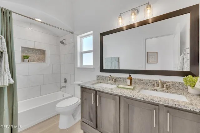 a bathroom with a granite countertop toilet a sink and mirror
