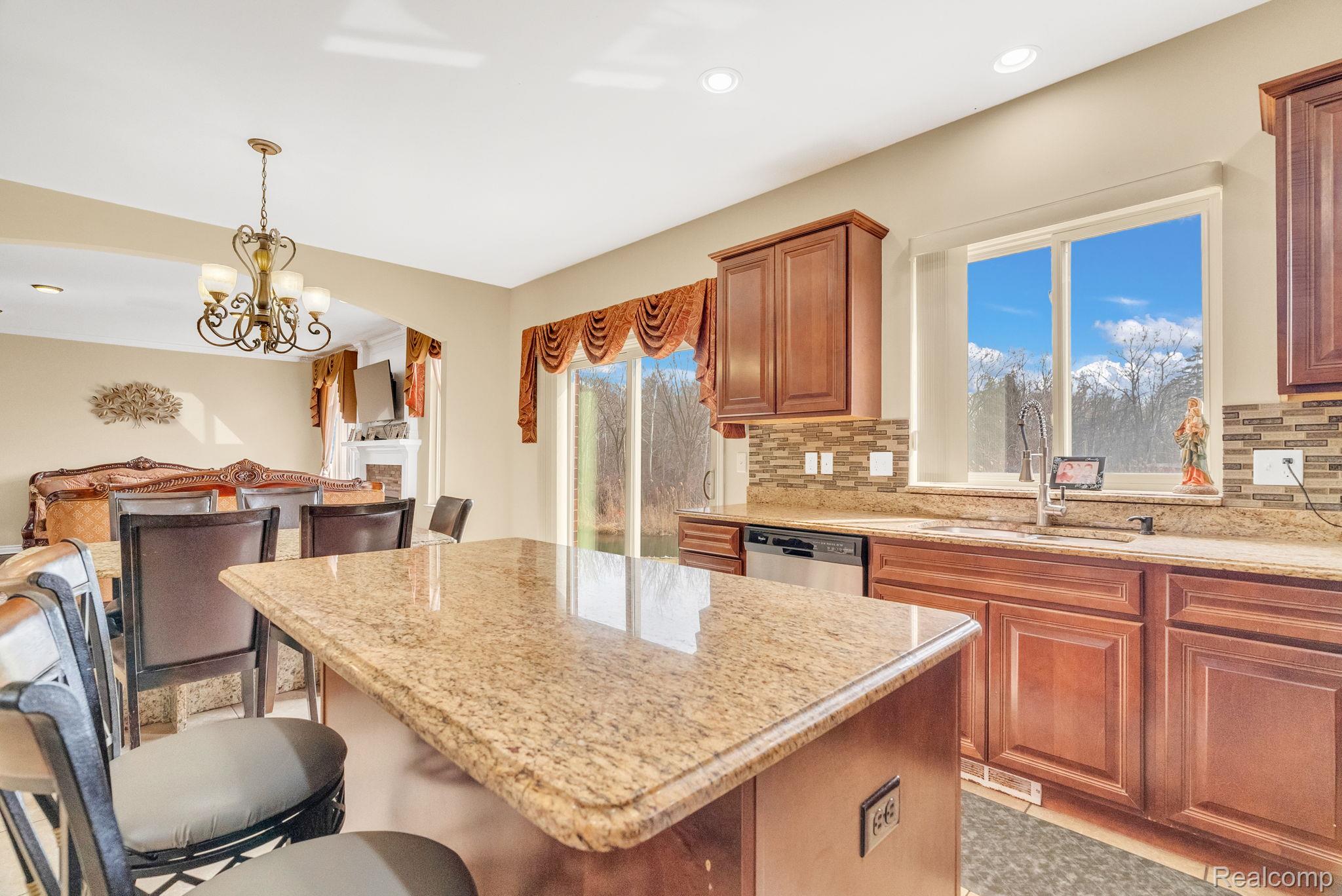 4122 Hawks Nest Road Utica, MI 48317 - Photo 30 of 74 Kitchen featuring tasteful backsplash, suspended lighting, a kitchen island, and a breakfast bar