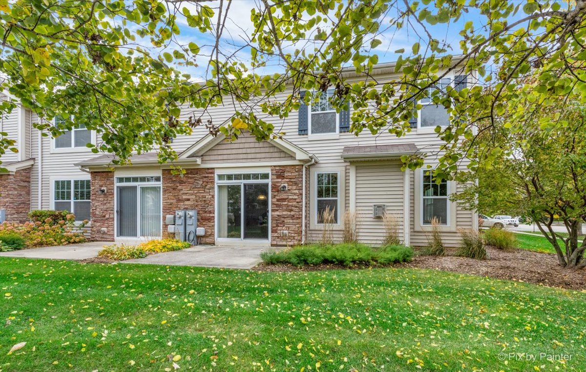 6-n307 Whitmore Circle, Unit A St. Charles, IL 60174 - Photo 16 of 18 a front view of a house with garden and trees