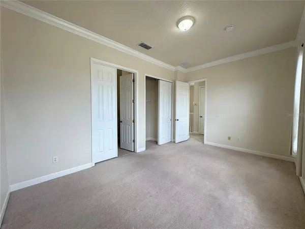 an empty room with windows and closet