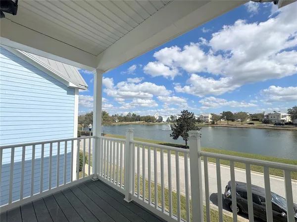 a balcony with wooden floor next to a yard