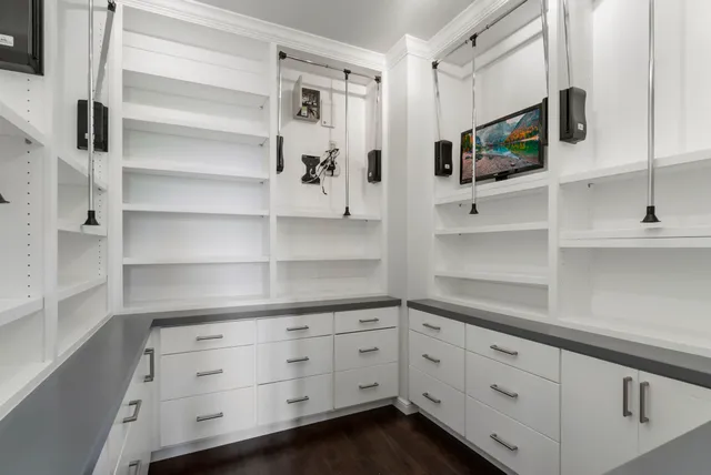 a kitchen with white cabinets stainless steel appliances and wooden floor