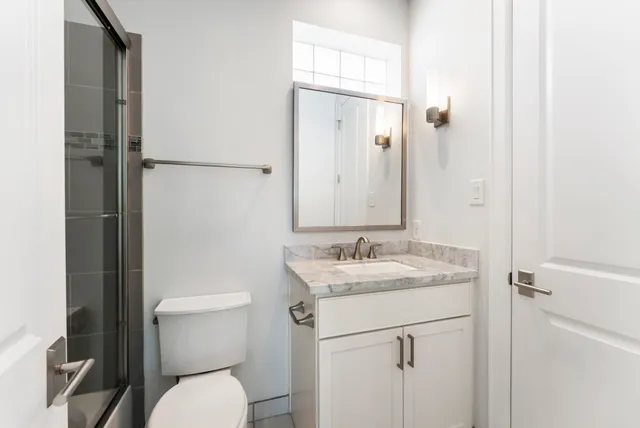 a bathroom with a granite countertop sink toilet and shower