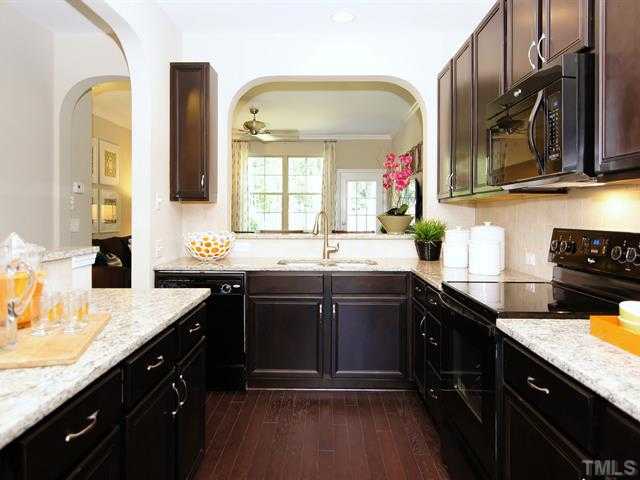 702 Wickham Ridge Road Apex, NC 27539 - Photo 2 of 10 a kitchen with a sink stove top oven and cabinets