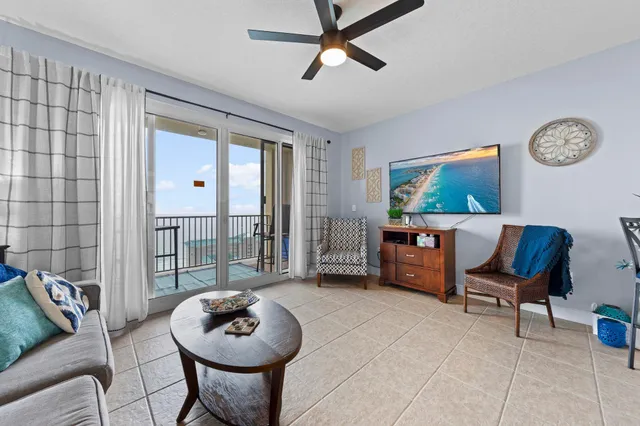 a living room with furniture and a dining table with kitchen appliances