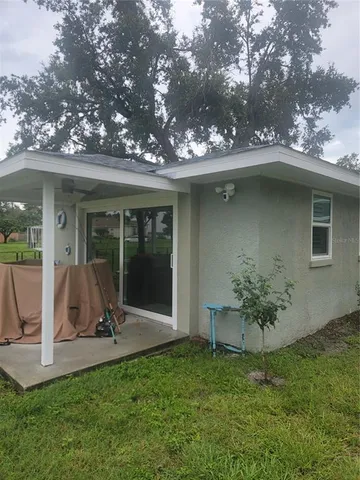 a view of a chair and table in backyard of the house