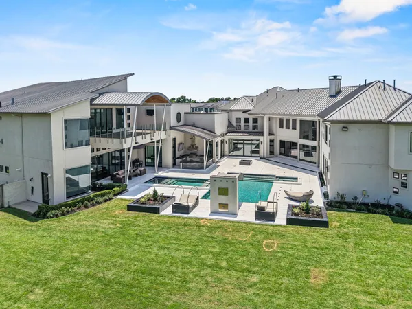 a view of a house with a big yard and large trees