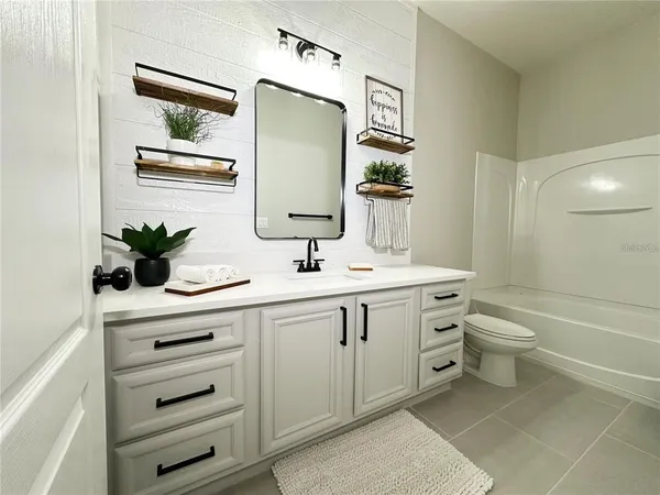 a bathroom with a double vanity sink a toilet and a mirror