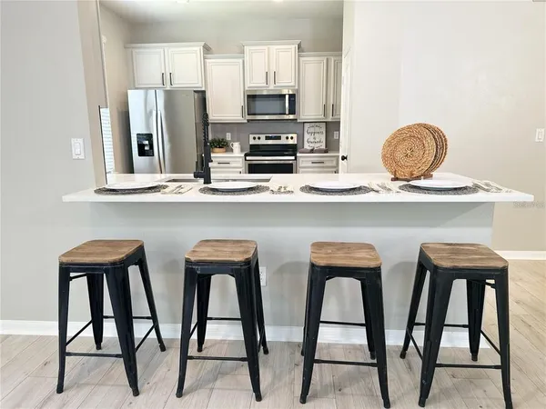 a kitchen with stainless steel appliances granite countertop a stove top oven and white cabinets